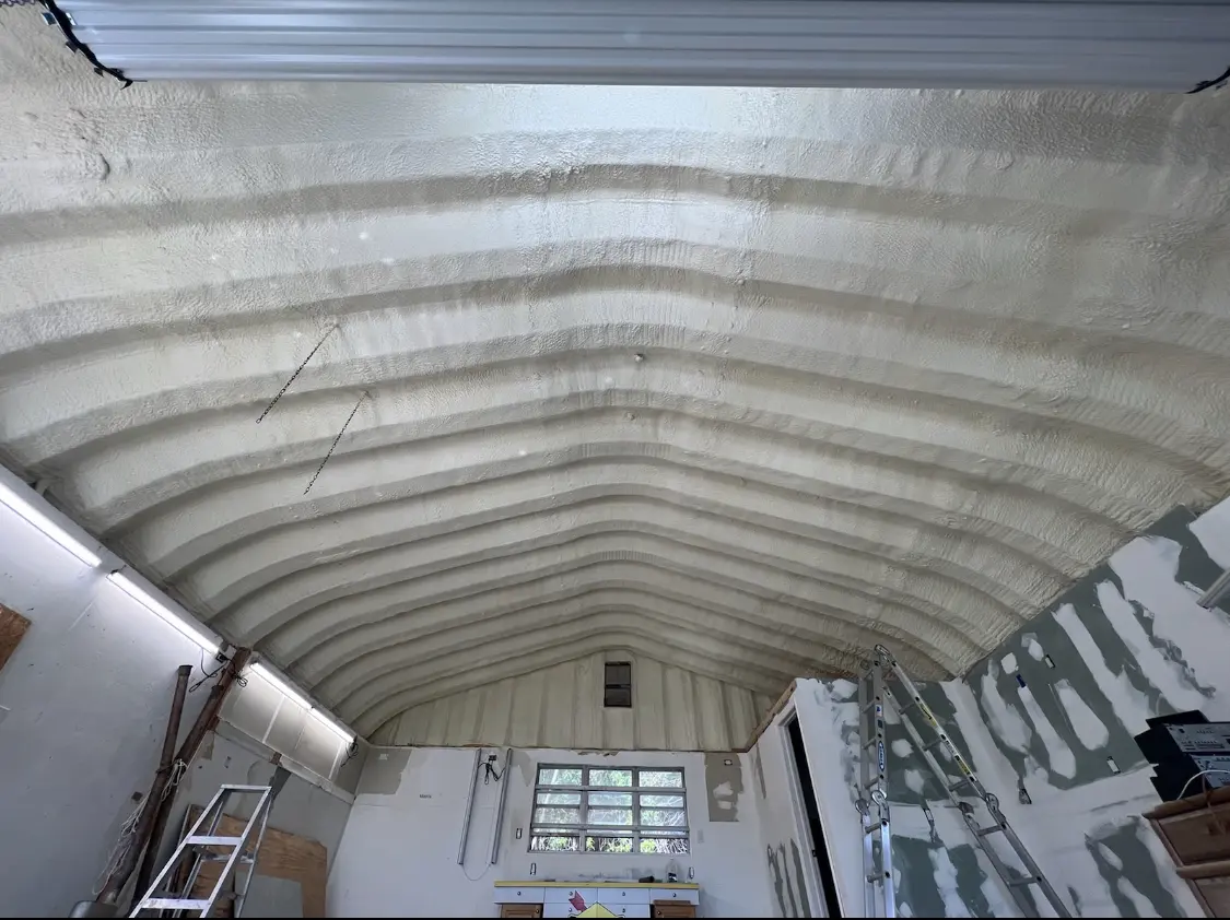 Spray polyurethane foam applied to the underside of a metal roof deck in Savage